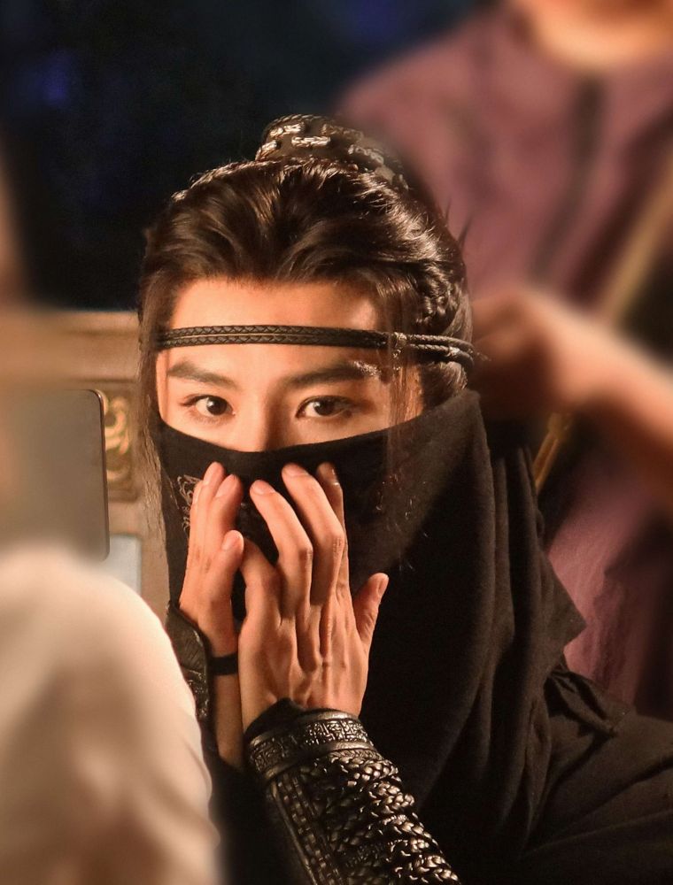 Xiao Shunyao in black headband and a half veil covering the lower part of hia face, his hands held up against it