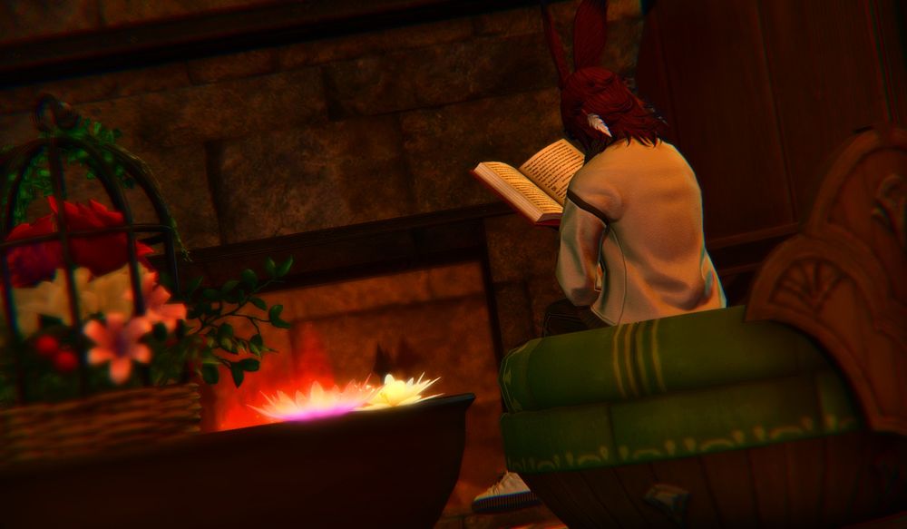 A Viera in a white jacket sits on a cushioned chair by the fire reading a book.