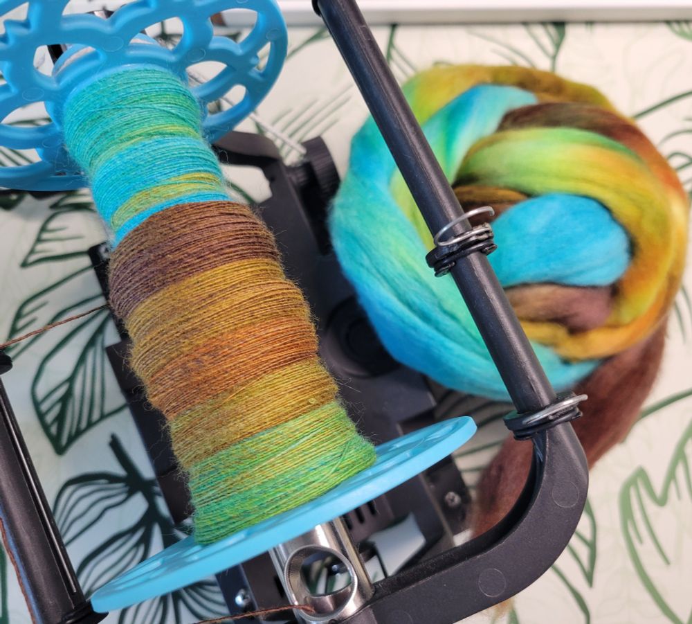 Partially handspun fiber in blue and brown on the eew 6.0 electric wheel