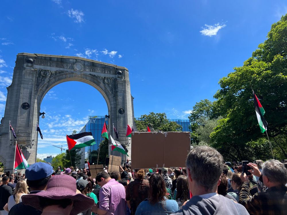 People waving Palestinian flags and listening to Palestinian New Zealanders talking at the Bridge of Remembrance in Christchurch