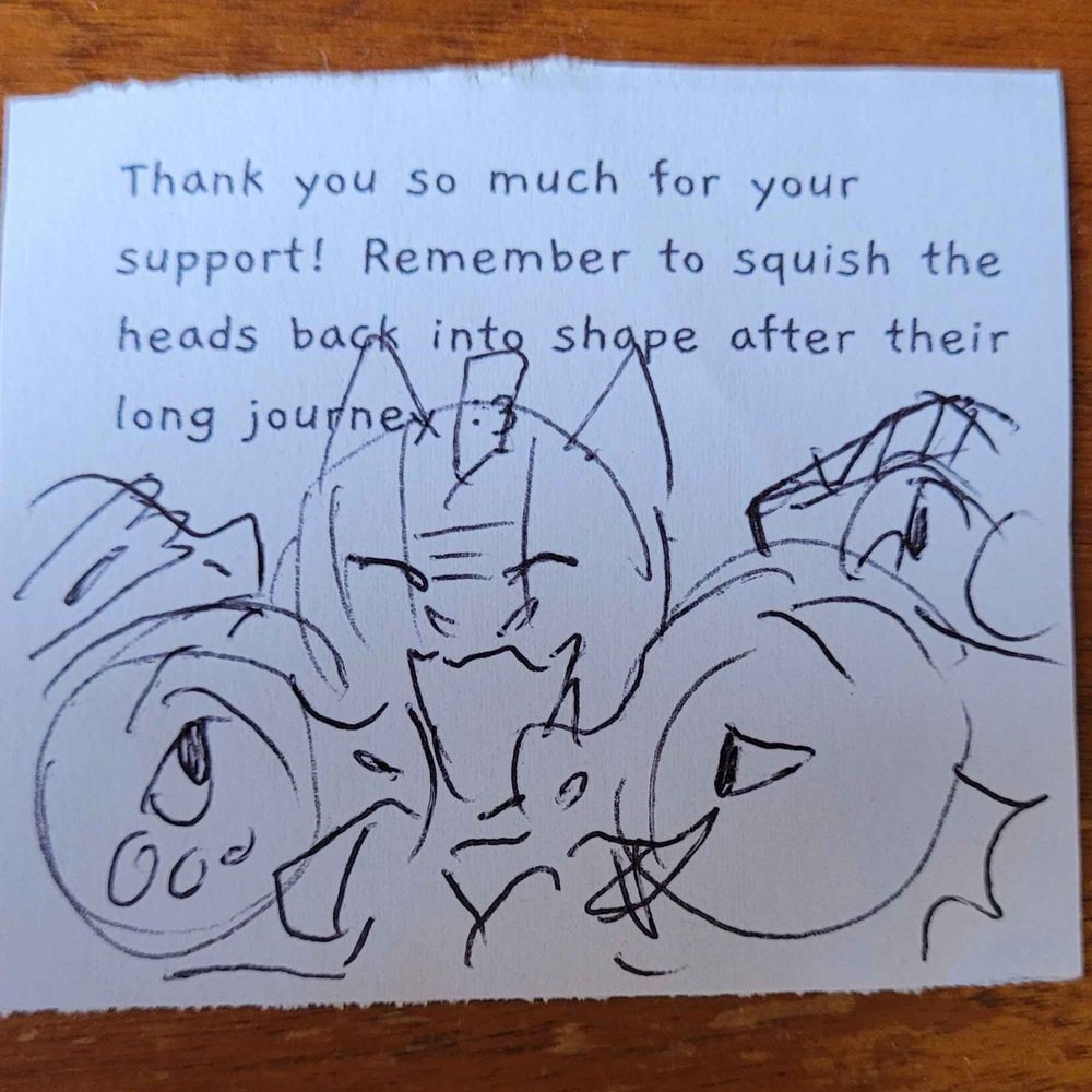 A photo of a small pen sketch of a few dragons on paper.