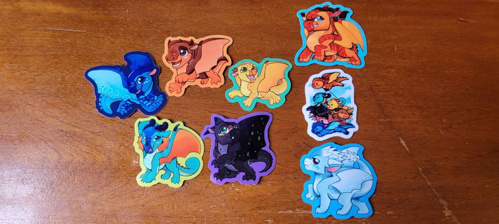 A photo of a set of stickers featuring characters from the book series Wings Of Fire.