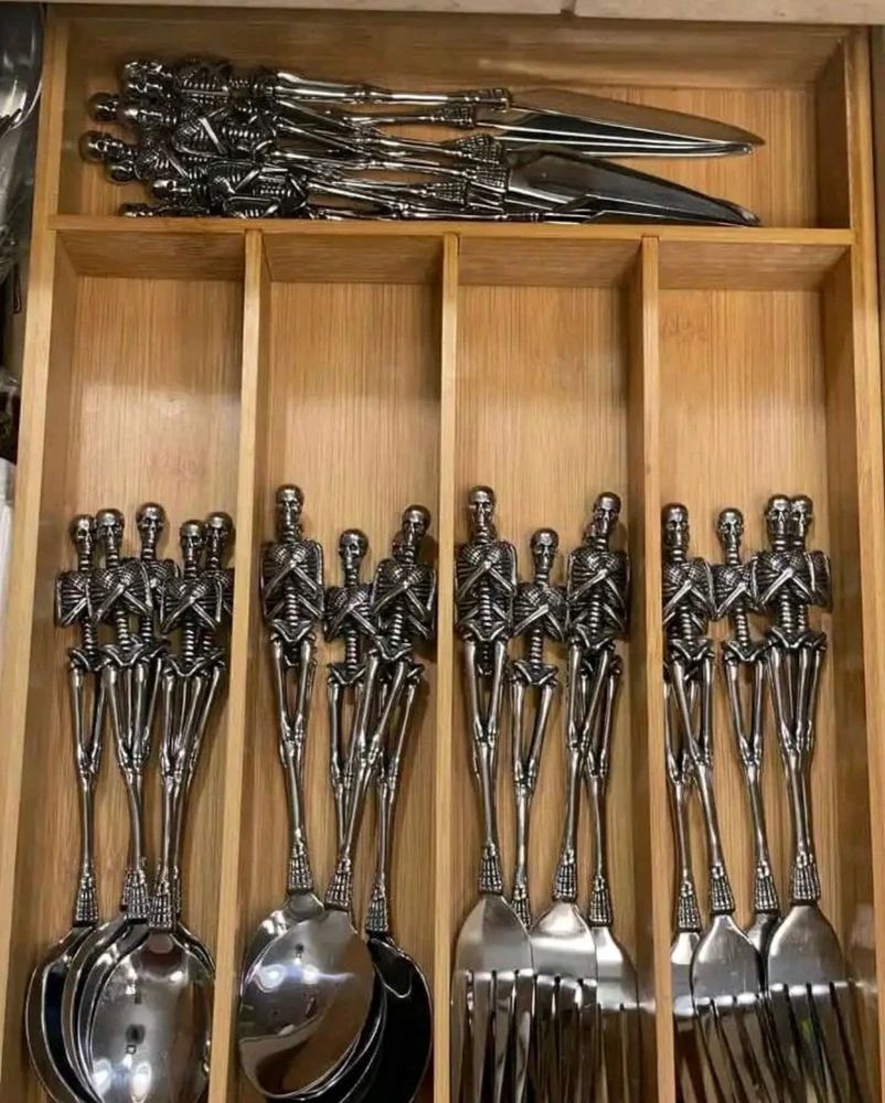 a bunch of knives, forks, and spoons with skeletons with their arms crossed as handles 