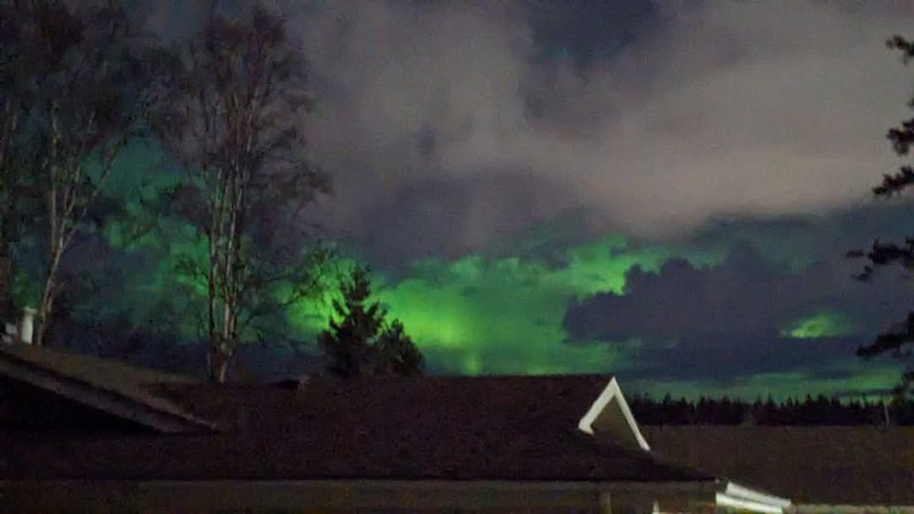 Bright green aurora showing through clouds
