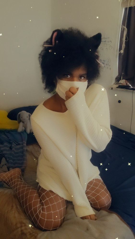 Cat girl angel sit on her bed wesring only a white sweater and white fishnets
