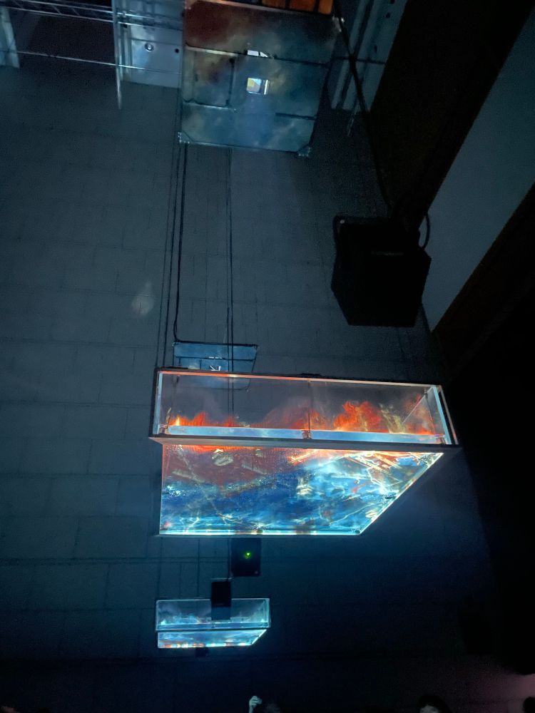 Water floating in a clear container in the air with images projected into the water