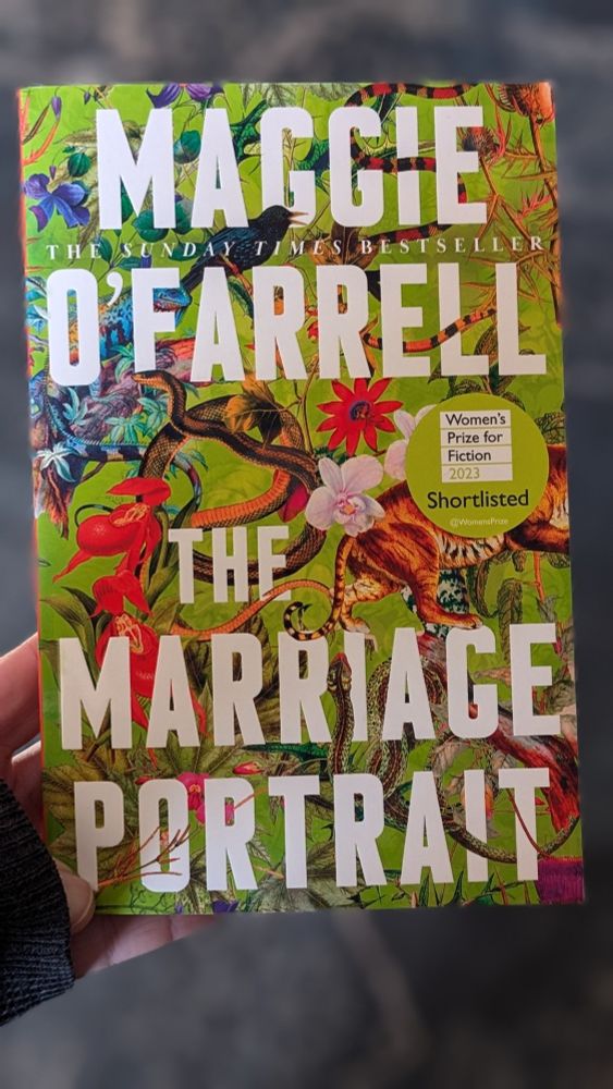 The paperback edition of THE MARRIAGE PORTRAIT by Maggie O'Farrell. The green background is covered in a collage of floral and animal imagery, including snakes, tigers, starlings, bearded lizards.