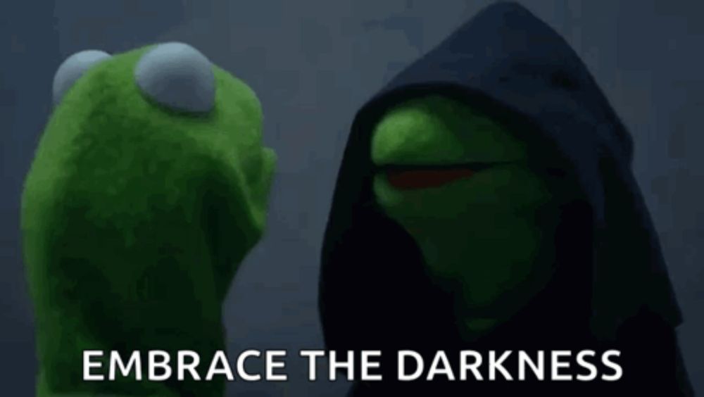 kermit the frog and darth vader from the muppets are standing next to each other in the dark .