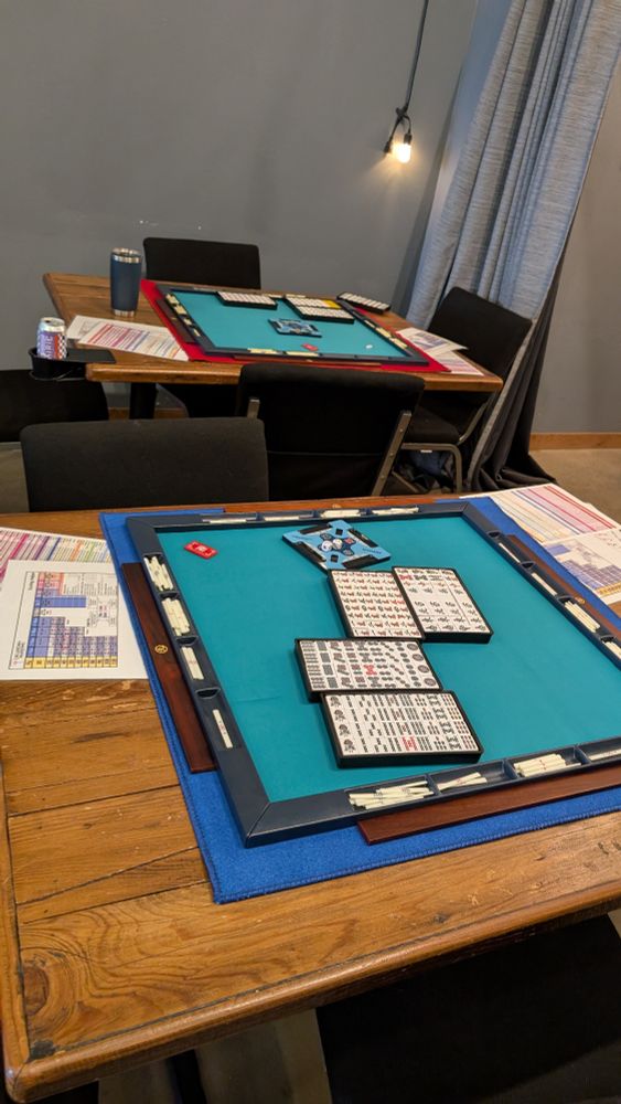 Coupla' tables with a coupla' Riichi mahjong sets.