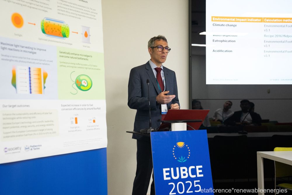 A person stands behind a lectern giving a presentation on alternative biofuels.