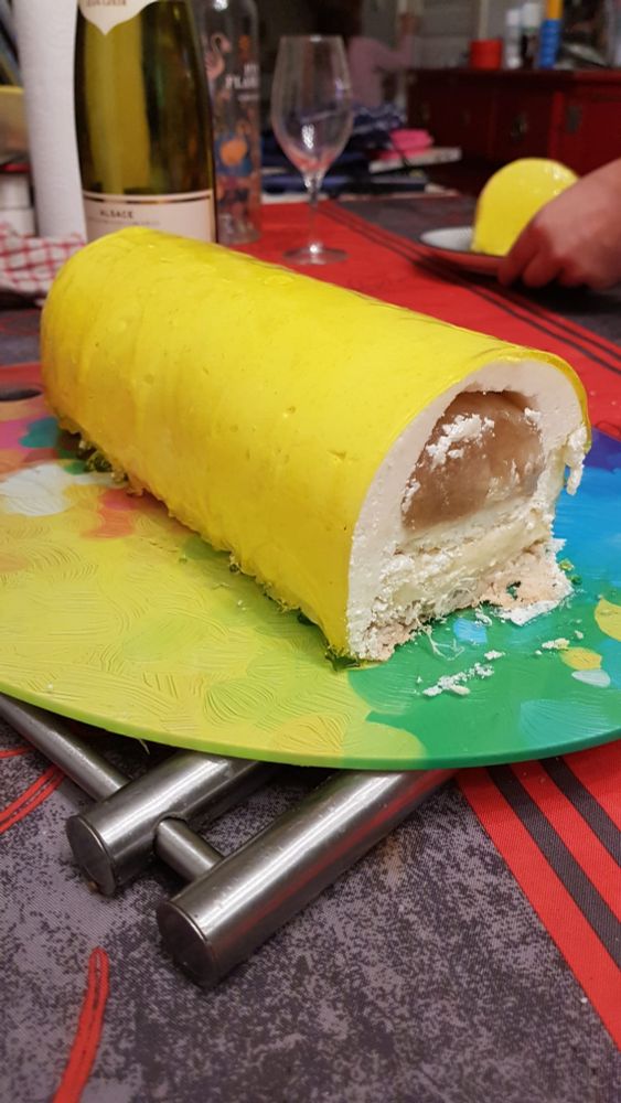 Entremet en forme de bûche au glacage jaune et dont on voit la découpe décrite sur la deuxième photo.
