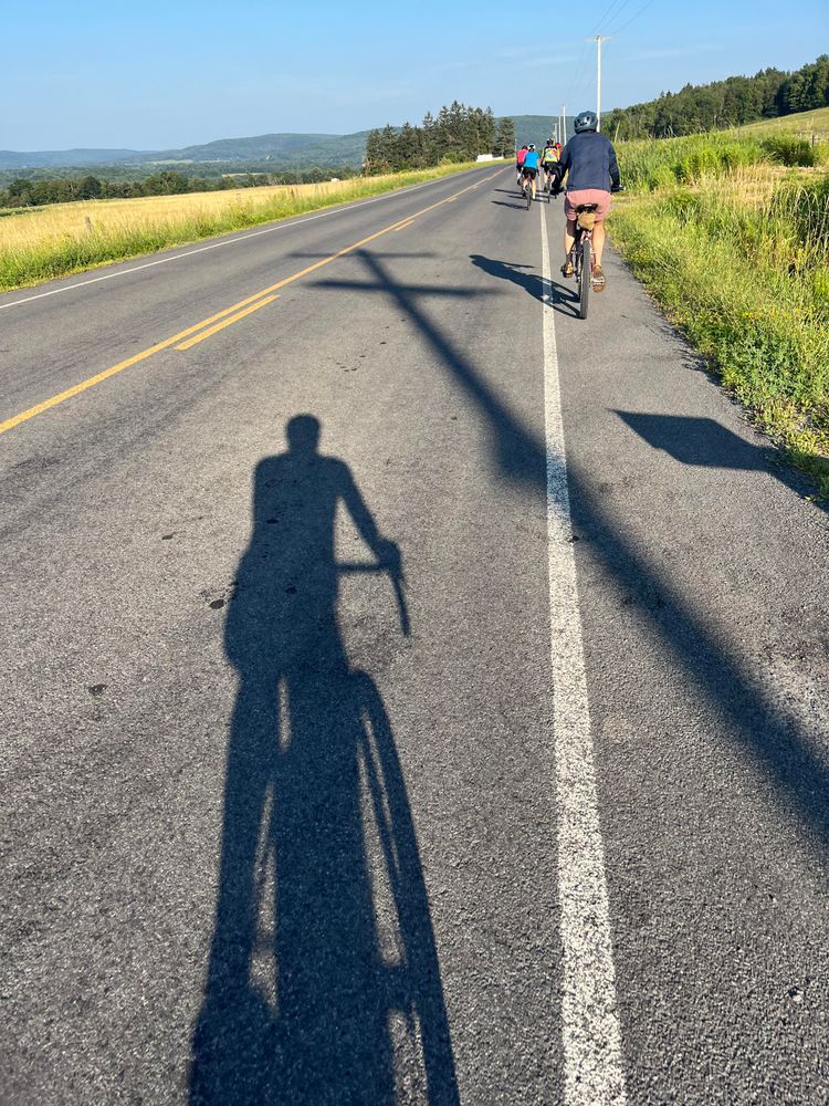 The shadow of a goofball on a bike.