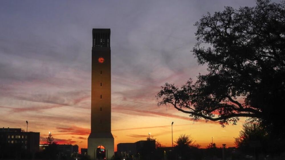 The sun setting behind Texas A&M University’s clock tower.