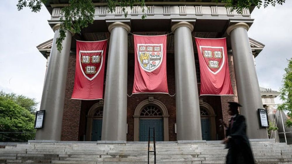 A photo of the Harvard campus with a graduate walking by.