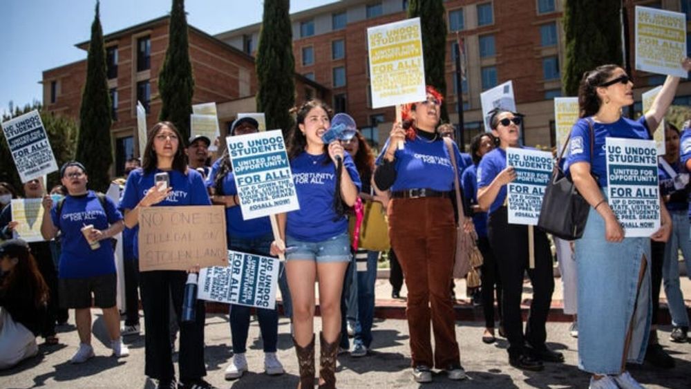 A group of students hold signs that read "United for Opportunity for All."