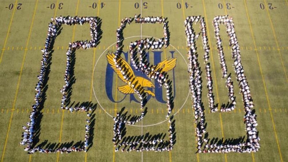 The letters "CSU" are spelled out on a football field by Coppin State University freshmen.
