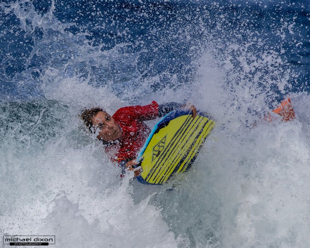 wave crashing over woman on a bodyboard
