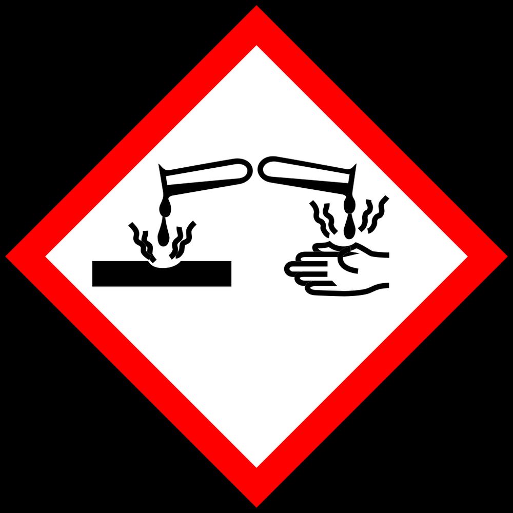 Image du pictogramme danger corrosif et acide dans un losange aux bordures rouge avec à l'intérieur une main qui a un trou et au dessus une fiole versant du liquide.