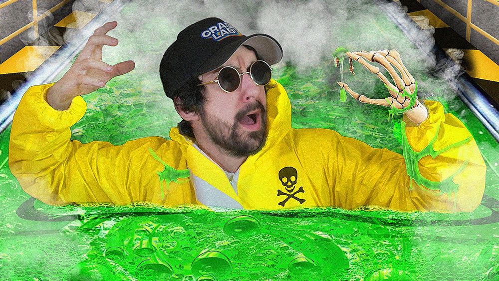 Moi au centre avec un air paniqué portant mes habituelles lunettes rondes noires, ma casquette Crashlab et habillé d'une tenue de protection jaune avec un tête de mort noire 
Ma main gauche est composée uniquement d'os parce que je baigne dans un acide vert 
En fond de la fumée blanchâtre 