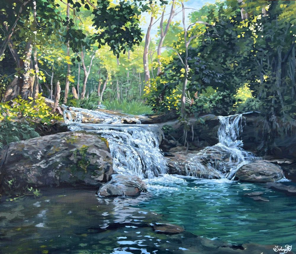 waterfall in Laos with sunlight shining through the trees