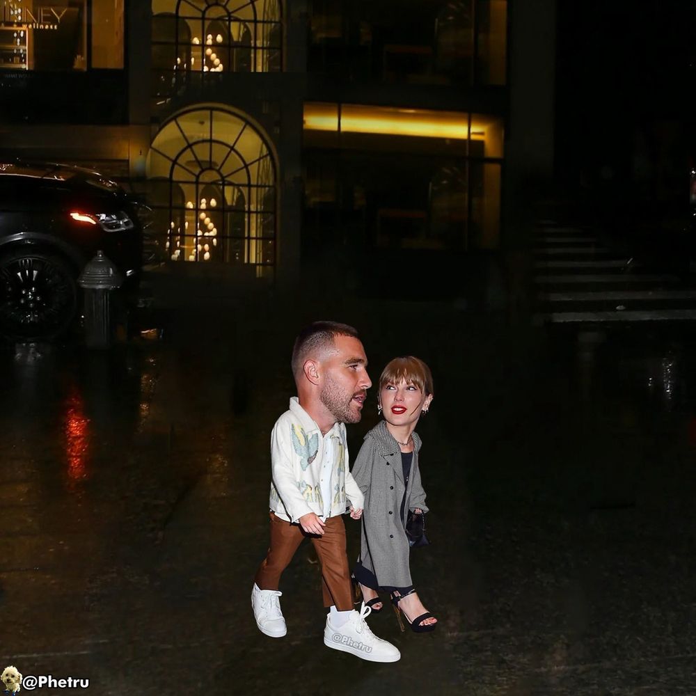 Shrunken Travis Kelce and Taylor Swift with big heads walking in a city, taylor is looking up at Travis as he speaks. Taylor is wearing long gray trench with black dress and black accessories. Travis is wearing white shirt with brown pants and white shoes.