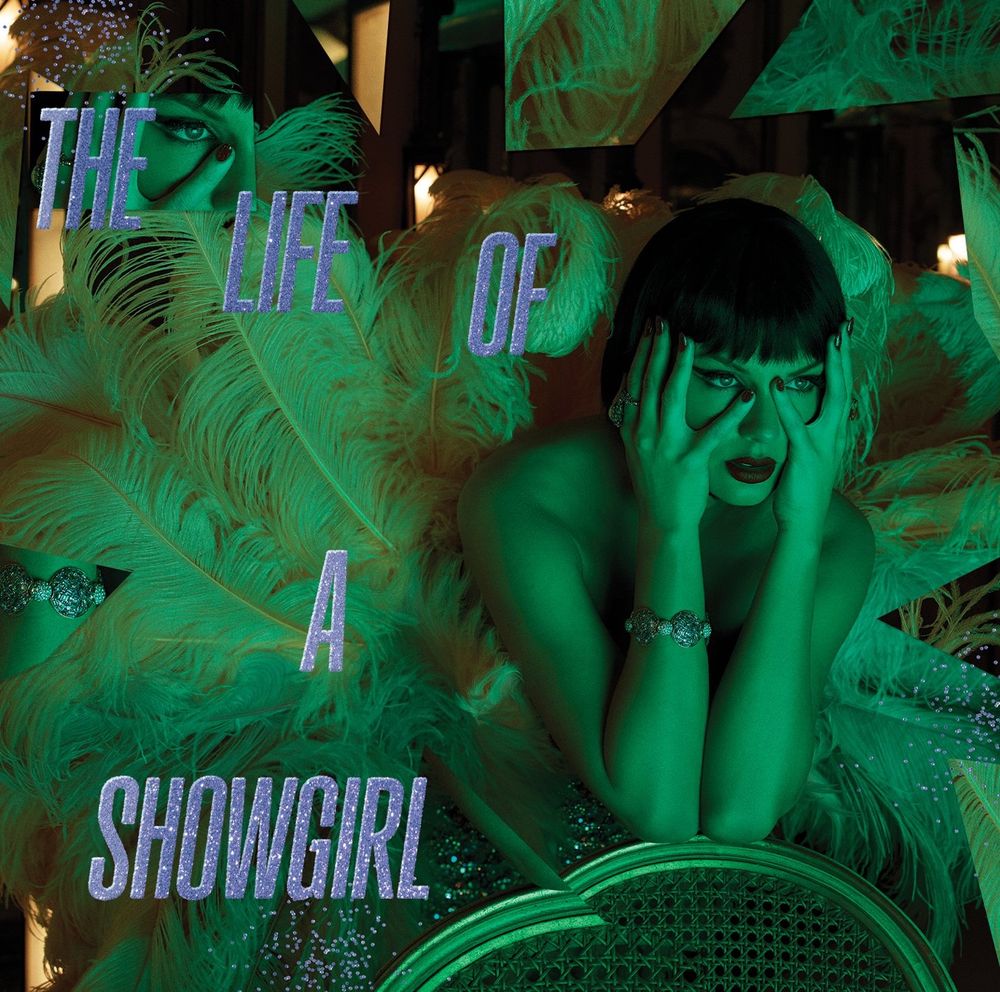 Taylor Swift in a green light holding her hands up to her face around her eyes and fiercely staring into the distance. She is leaning on a chair and she has a showgirl outfit on with tons of feathers all around her. Her hair is a short brown Bob!, and she also has a red lip.