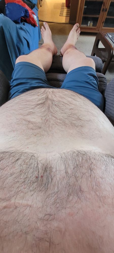 POV shot in the recliner showing my furry chest, tummy, and bare feet. I'm wearing only a pair of blue shorts. 