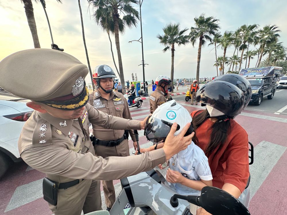 Polizist setzt Kind auf Motorrad Helm auf.