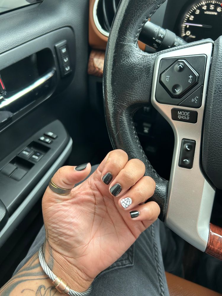 Halloween themed nails, black background with spiders. Short