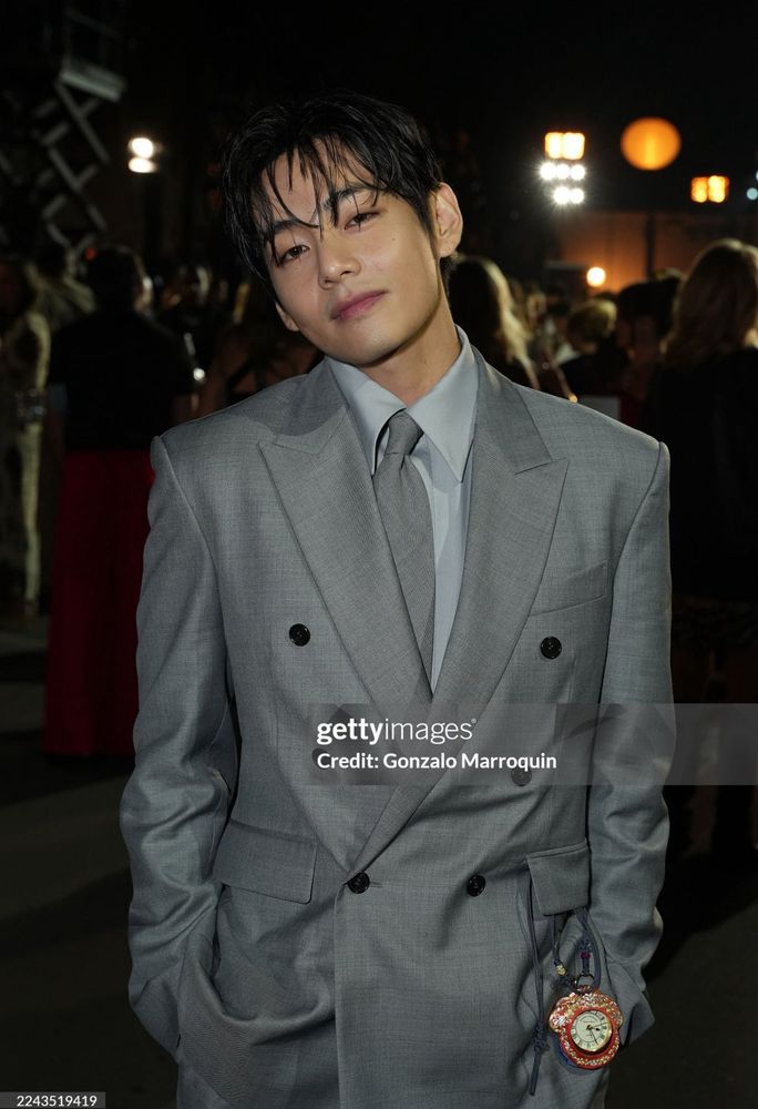 Taehyung in LA dressed in a light gray suit and looking dreamily at the camera through wispy bangs. It's from getty images so it's not edited at all, but he still looks perfectly flawless like some divine being, like HOW???