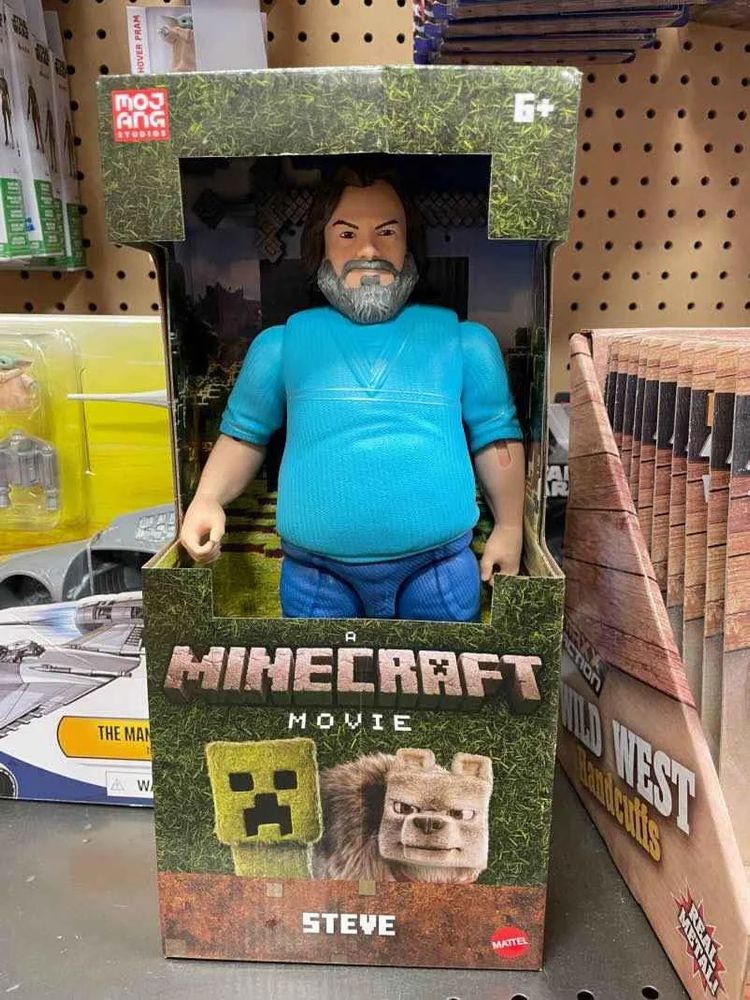 A Minecraft movie action figure depicting Steve. It does not look like Steve as he appears in the Minecraft game, but rather just looks like Jack Black wearing jeans and a light blue shirt.