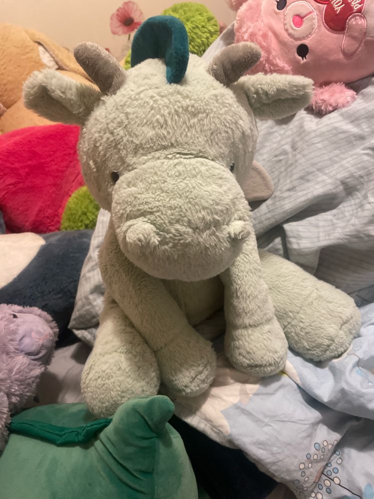 A Picture of a green dragon plushie sitting down