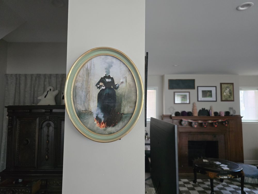 art print from artist duo "Strong and Hardy" purchased at the Oddities and Curiosities expo in a seafoam green oval-shaped frame with gold detail