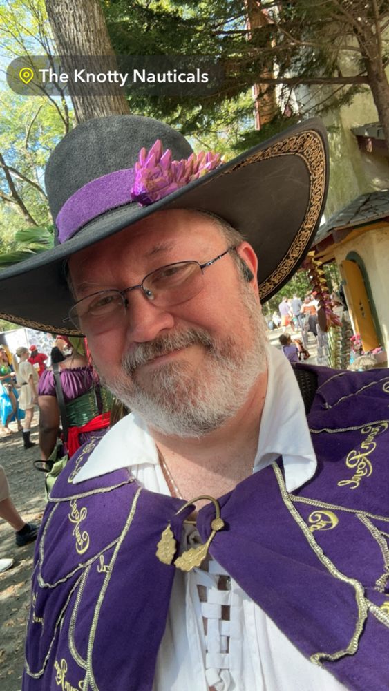 Me, wearing my Renaissance Festival garb. Broad brimmed hat with dragon.  Crown Royal cloak with oak pin