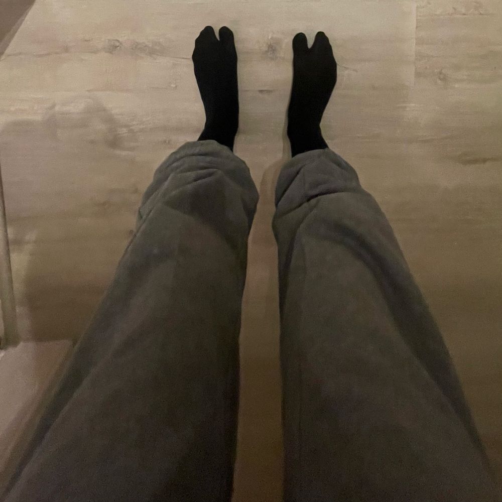 Weitwinkelaufnahme von Füßen in Zehentrennersocken