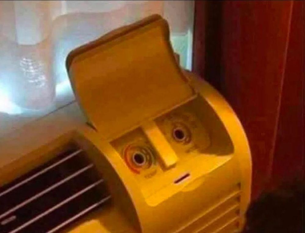 Photo d'un radiateur dont le panneau de comande donne une paréidolie d'un visage avec une bouche circonspecte et des yeux écarquillés