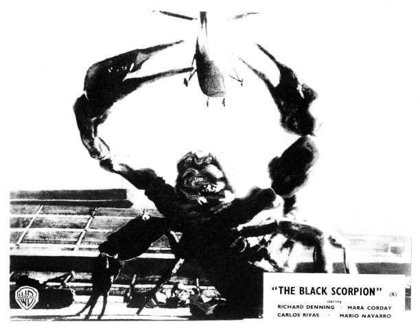A UK lobby card for THE BLACK SCORPION (1957), showing the gigantic scorpion of the title reaching up to grab a helicopter. 