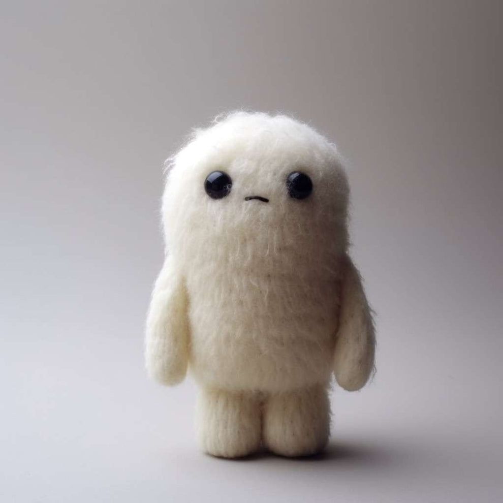 A small frowning yeti Plush with black beady eyes.