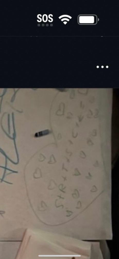 A tablecloth with crayon writing on it and there’s a giant heart with the letters S+R+T+S etc. surrounded by a bunch of hearts 