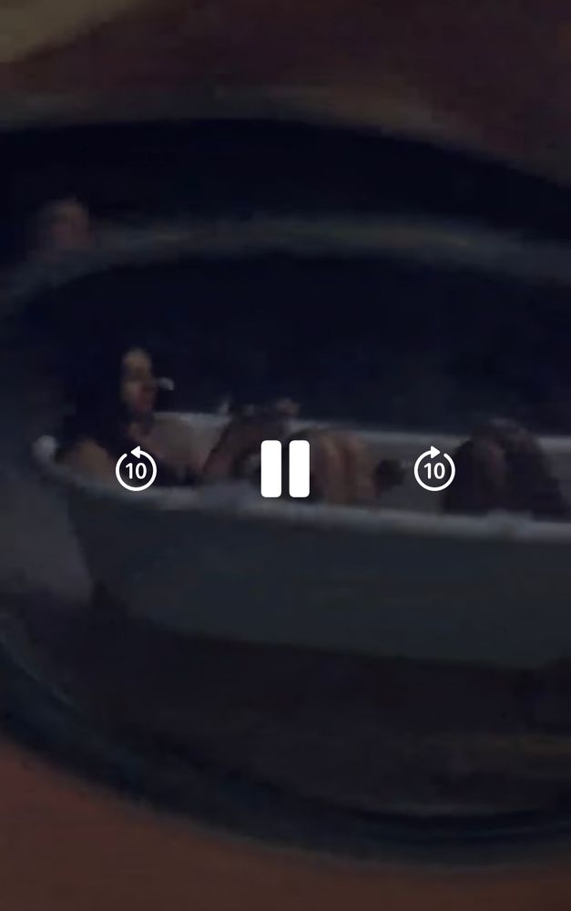 A reflection of sunglasses of 2 people in a white bathtub 
