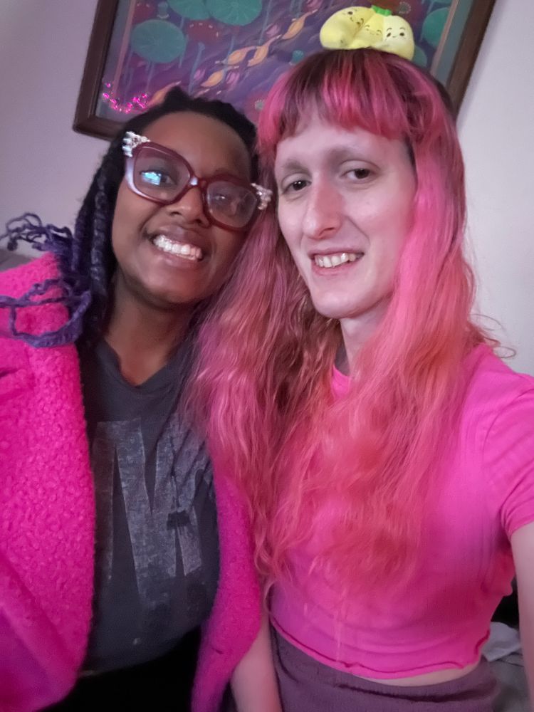 Gwynn and Miss cervix sitting on the couch next to each other smiling. 