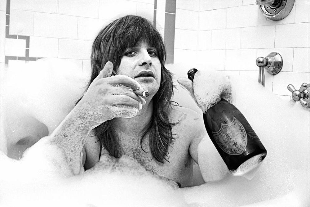 Ozzy in a bubble bath drinking Dom Perignon and smoking a cigar. Shot by Mark Weiss at the Plaza Hotel NYC in 1981