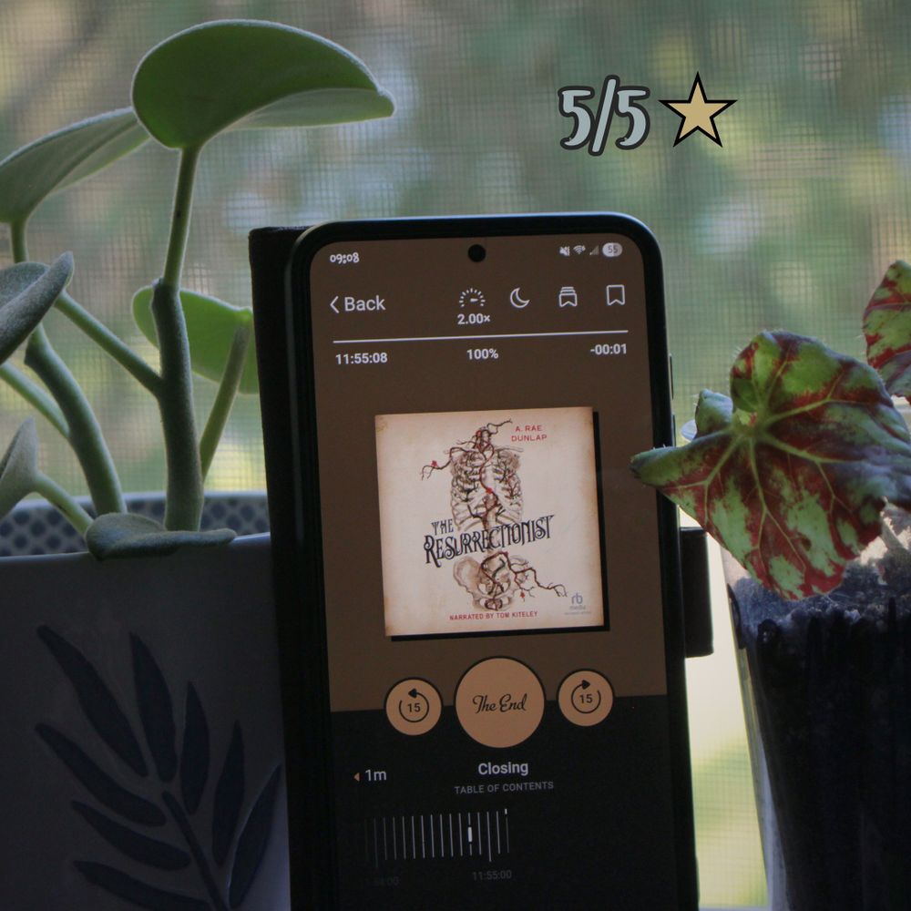 The Resurrectionist by A. Rae Dunlap audiobook 100% complete on a phone surrounded by plants