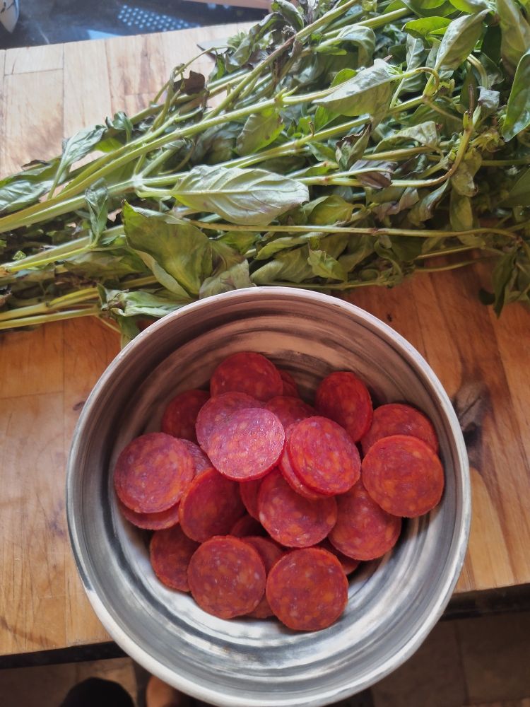 Sliced pepperoni, bunch of basil.
