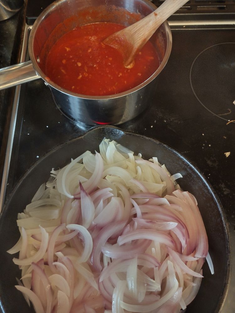 Pot of red sauce, pan of caramelizing onions.