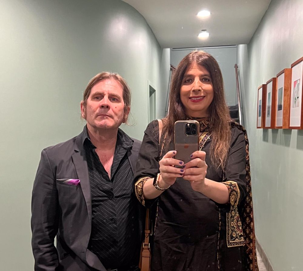 Man and woman dressed to go out and taking a photo in a mirror