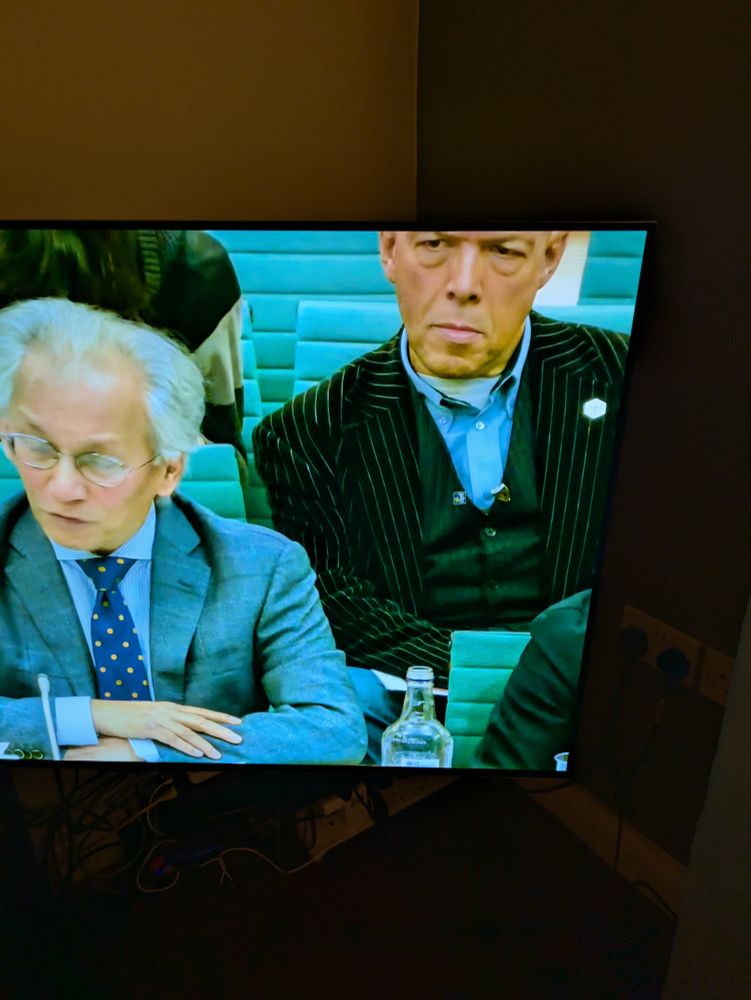 Capture of TV still of two people at a Parliamentary committee meeting. 