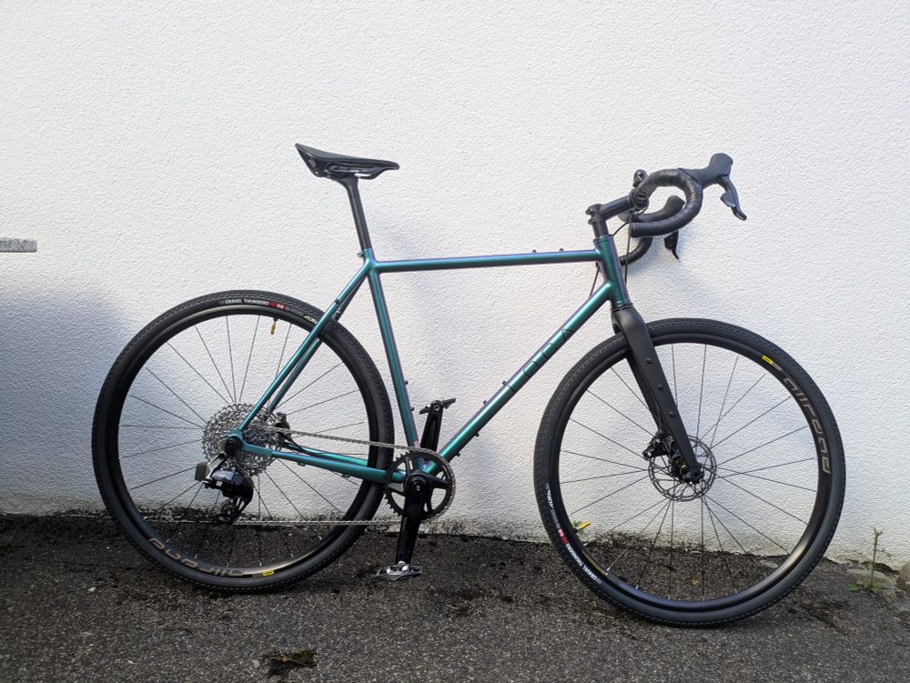 Ein Crossrad vor einer weißen Wand. Das Rad ist grün. 