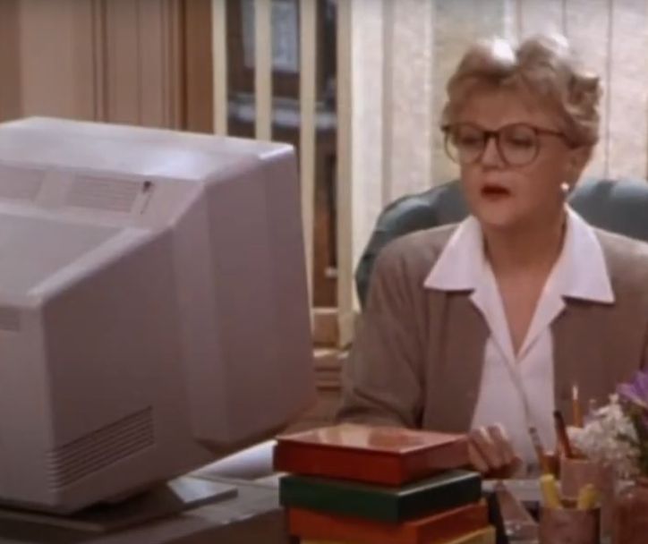 J. B. Fletcher in a pantsuit in her New York apartment, working at an early 1990s desktop PC.