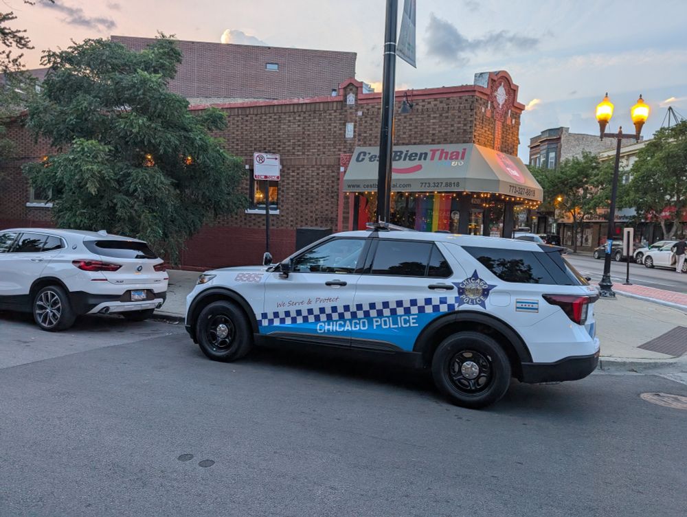 A CPD SUV parked in the no parking tow zone outside C'est Bien Thai.